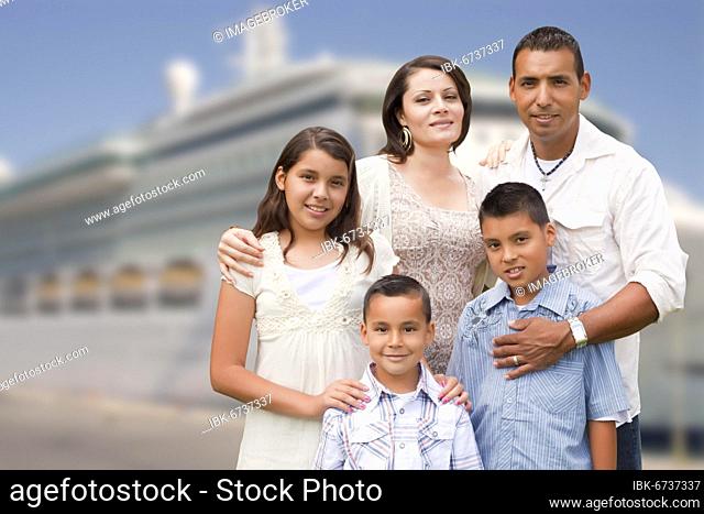 Young happy hispanic family on the dock in front of a cruise ship