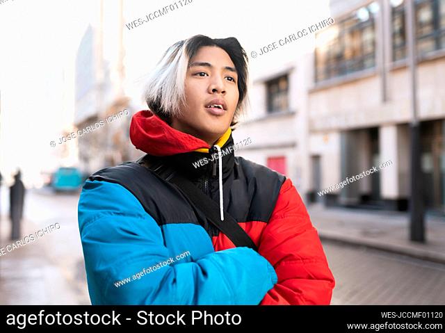 Asian man with arms crossed in city