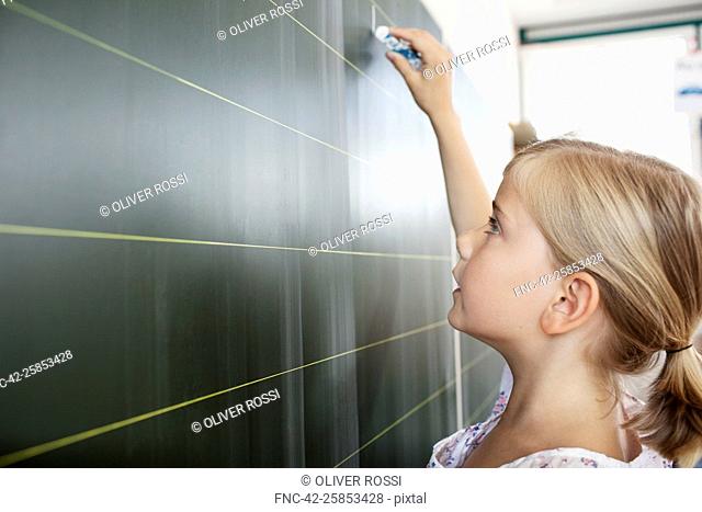 Girl writing on blackboard