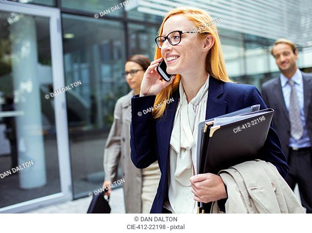 Businesswoman talking on cell phone outside of office building