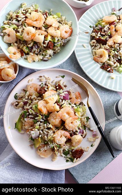 Rice salad with avocado, sun-dried tomatoes, onions and prawns