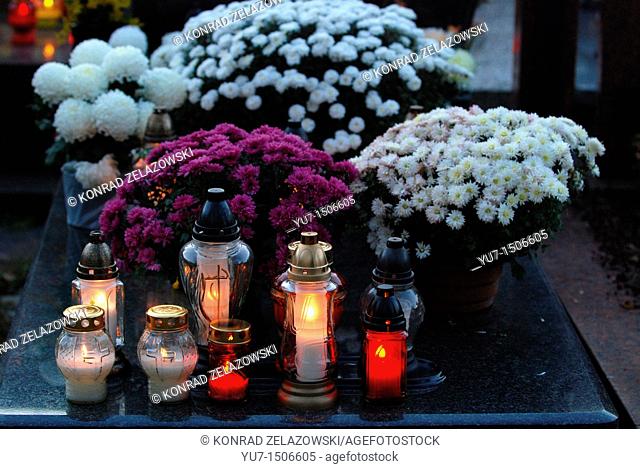 Chrysanthemums and candles on Wolski cemetery in Warsaw, Poland during All Saints Day