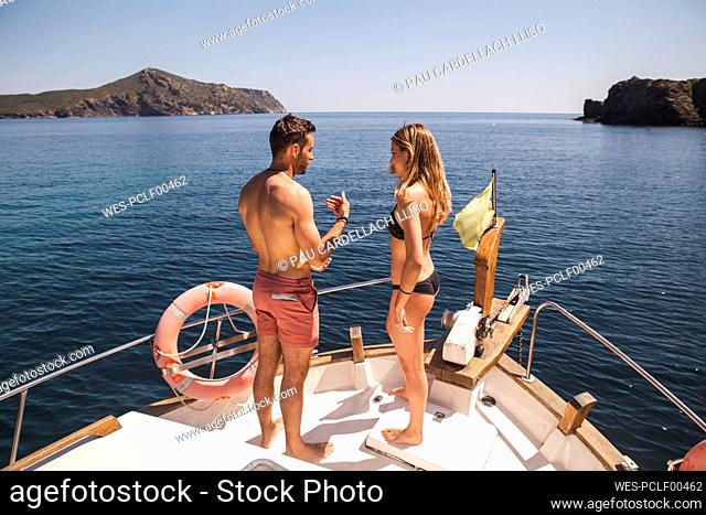 Man talking to woman wearing bikini on boat