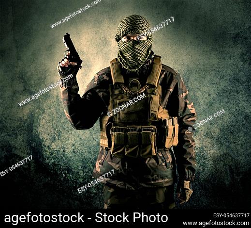Portrait of a heavily armed masked soldier with grungy background concept