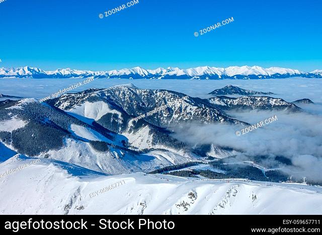 Ski resort Jasna. Winter Slovakia. Panoramic view from the top of the snow-capped mountains and fog in the valleys