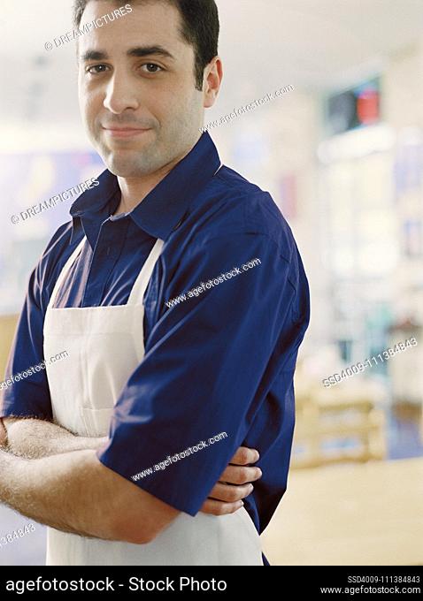 Man wearing apron with arms crossed