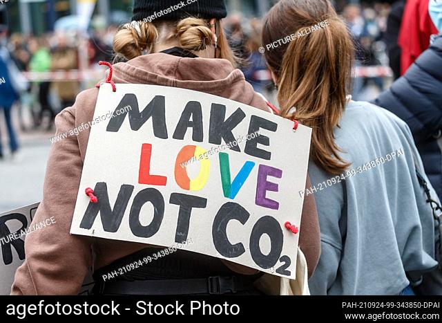 24 September 2021, Hamburg: A demonstrator carries a sign with the inscription ""Make Love Not CO2"" at the climate strike demonstration of ""Fridadys For...