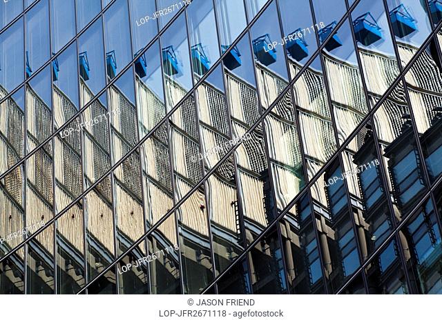 England, London, City of London. The Lloyds building is reflected in the mirror face of nearby offices to create an abstract view of modern architecture in the...