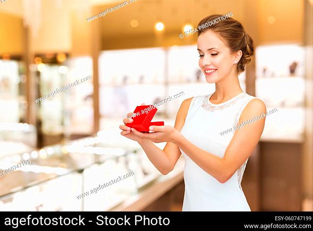 smiling woman with red gift box at jewelry store