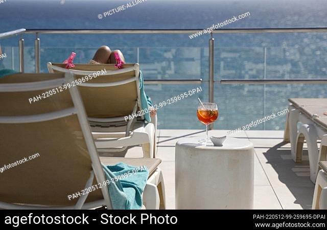 PRODUCTION - 11 May 2022, Spain, Palma: A customer sunbathes on the roof terrace of the Iberostar Bahia de Palma hotel on Arenal beach in Mallorca