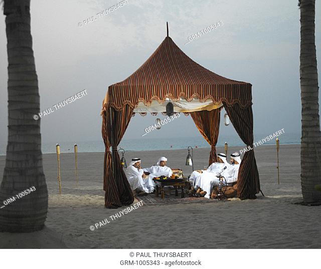 Ramadan: Arab men sitting in Arabian tent for Iftar (fast-breaking meal after sunset)