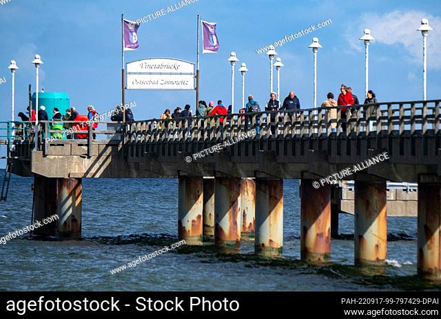17 September 2022, Mecklenburg-Western Pomerania, Zinnowitz: Tourists and excursionists are on the pier on the beach of the island of Usedom in sunny weather