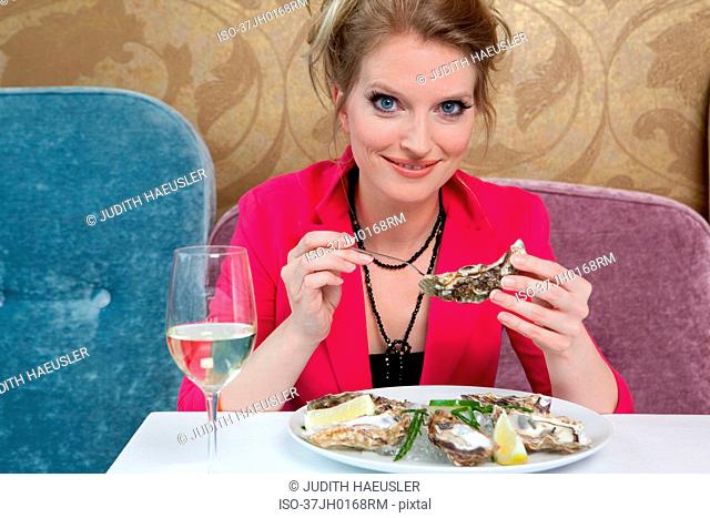 Woman having oysters in restaurant