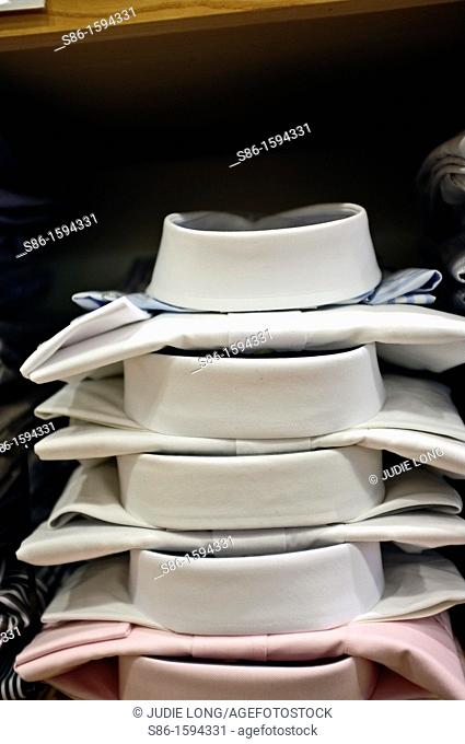 Stack of Men's White Dress Shirts Displayed in a Retail Clothing Store