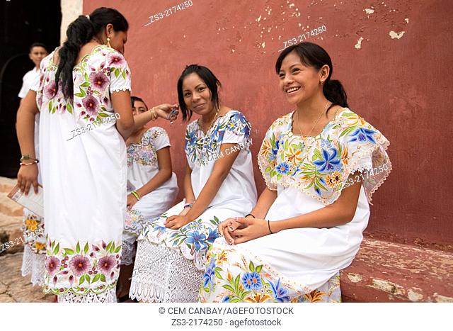 Young women sitting at the entrance of the church, building once functioned as a Franciscan Monastery, Valladolid, Yucatan Province, Mexico, North America