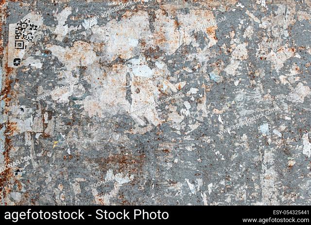 Texture of a grungy wall with torn posters. Ideal for textures and backgrounds. Retro style