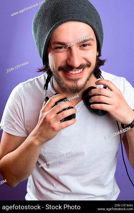 portrait of young man with headphones against color background