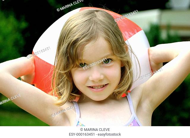 Mädchen im Sommer mit einem Wasserball