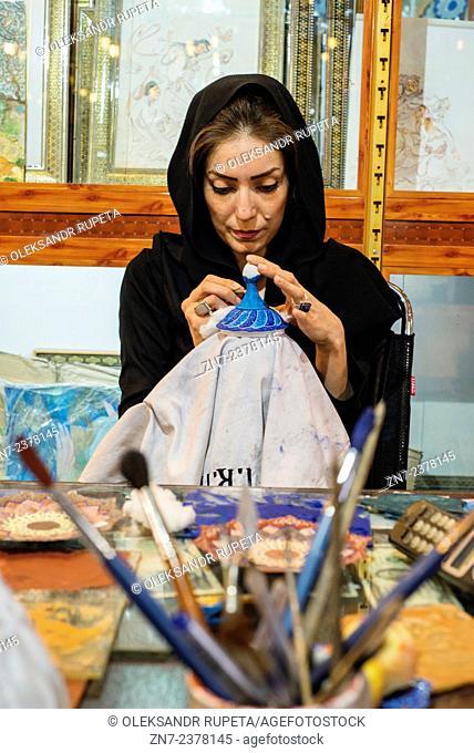 Ahmadi Enamelling, licensed artist of Cultural Heritage Organization, paints cooper vase in her shop, Esfahan, Iran