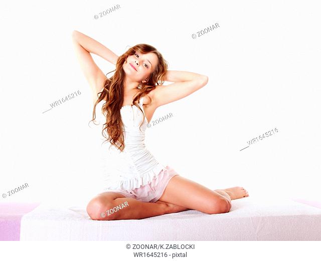 woman waking up in bed and stretching her arms up