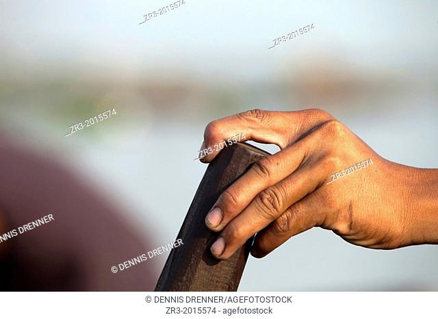 Detail of a fisherman's hand at work on the Mekong River early in the morning outside of Phnom Penh, Cambodia