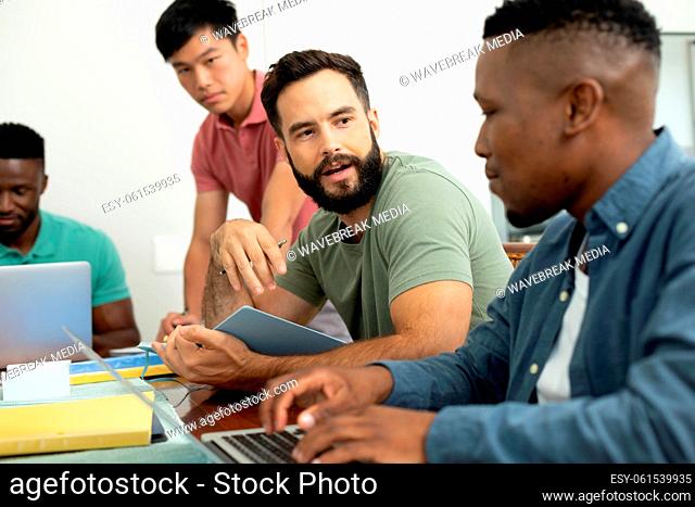 Multiracial male coworkers brainstorming ideas and strategies for achieving business goals