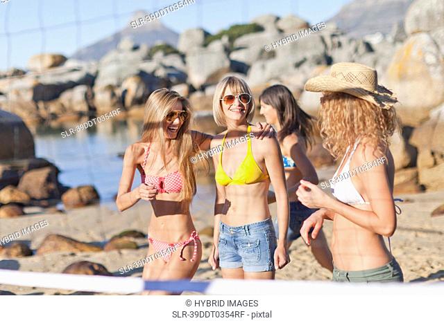 Smiling women playing beach volleyball