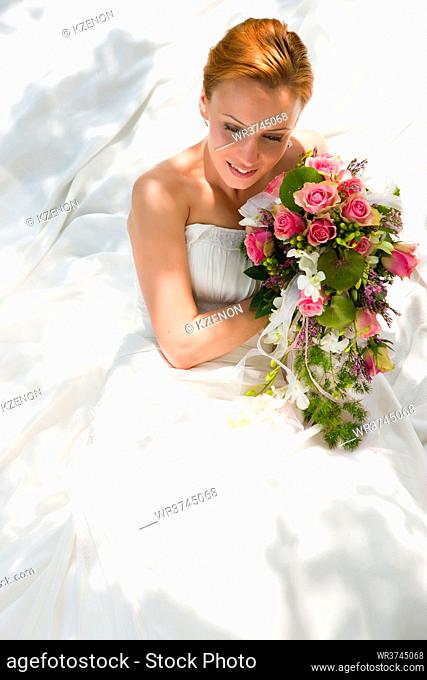 Bride sitting holding a bouquet of flowers in her hand