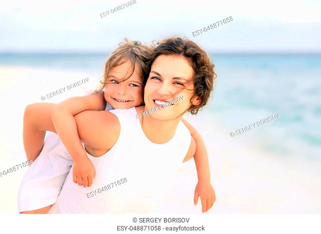 Portrait of happy mother and little daughter on sunny beach on Maldives at summer vacation