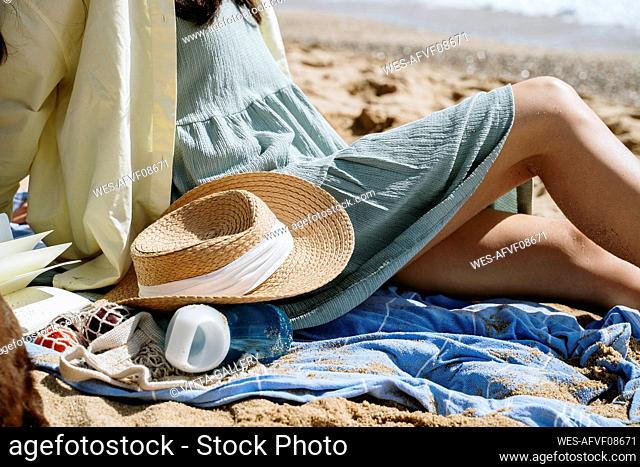 Woman sitting at beach during sunny day