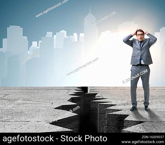 Businessman standing scared next to cliff
