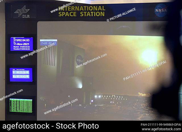 11 November 2021, Bavaria, Oberpfaffenhofen: The flames of a SpaceX Falcon 9 rocket can be seen on a large video screen in the Columbus Control Center at the...