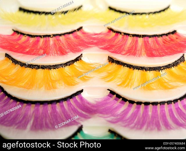 multi-colored false eyelashes in plastic packaging on a white background, close up