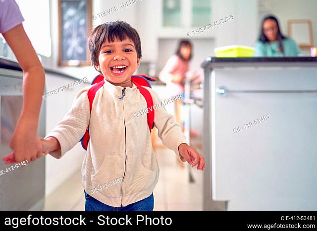 Portrait happy boy in kitchen with family