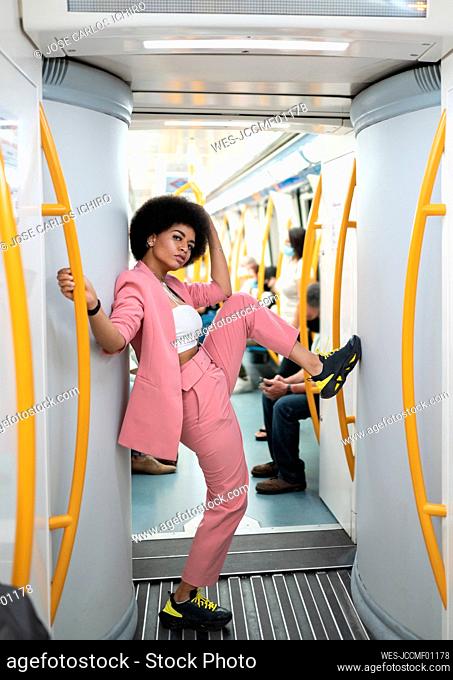 Female hipster with leg-up standing in train