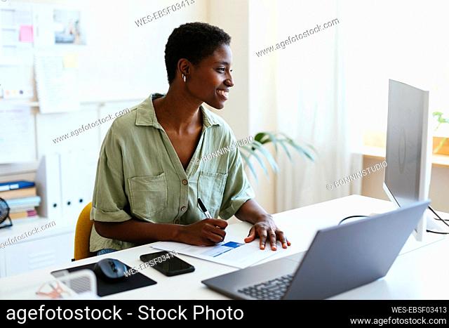 Smiling freelancer working on computer at home