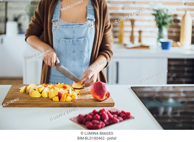 Caucasian woman chopping fruit in kitchen