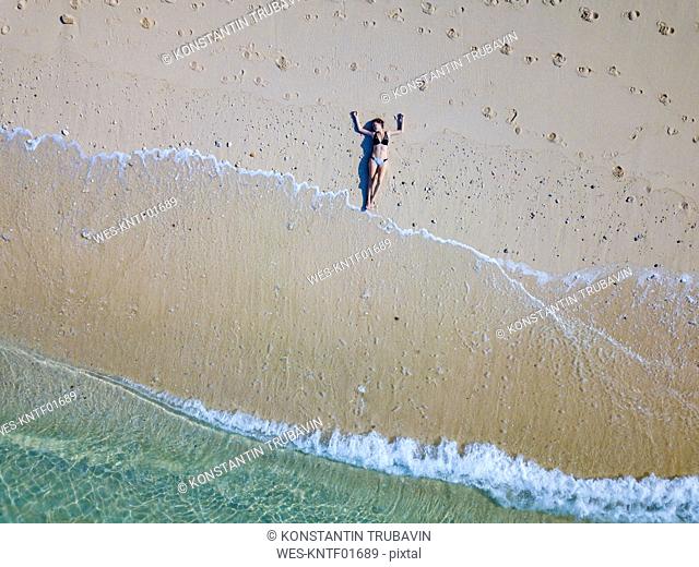 Indonesia, Bali, Melasti, Aerial view of Karma Kandara beach, woman lying on beach