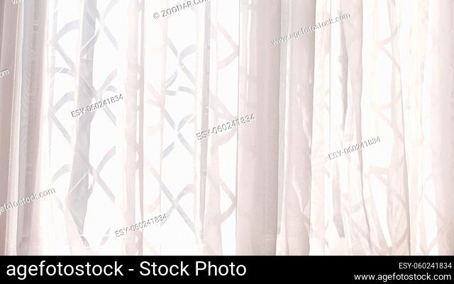 White voile or net curtain hung at criss cross design window. High quality photo with copy space