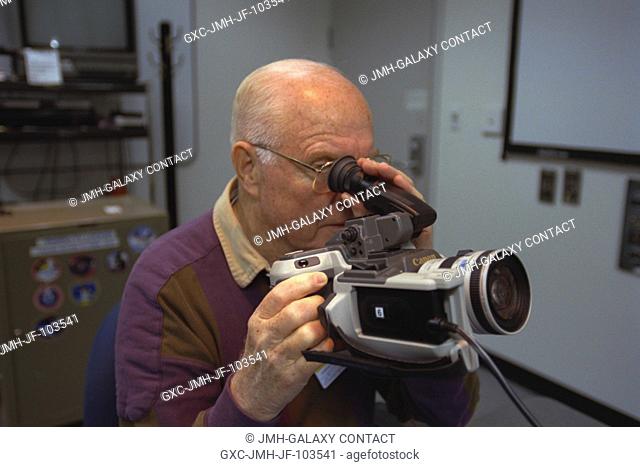 Looking through the view finder on a camera, U.S. Sen. John H. Glenn Jr. (D.-Ohio)gets a refresher course in photography from a JSC crew trainer (out of frame