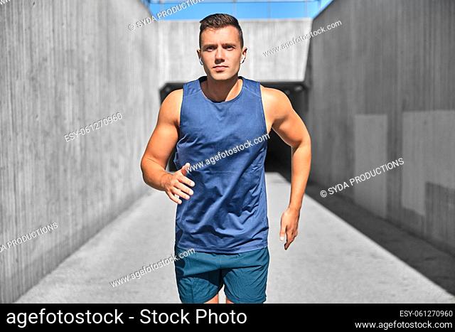 young man with wireless earphones outdoors