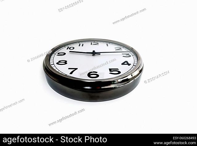 Analog clock with the hands hanging on a white wall seen from below. Time concept. Hurry and deadlines