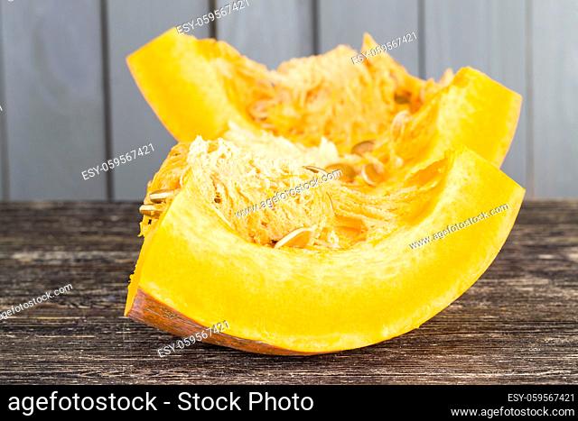 ripe orange pumpkin cut into square and other pieces, close-up of raw food for cooking