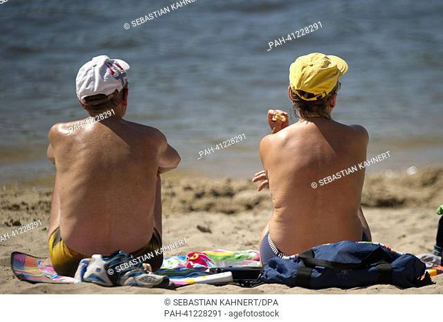 Two people sit on the beach at Blue Lake near Garbsen,  Germany, 23 July 2013. Photo: SEBASTIAN KAHNERT | usage worldwide