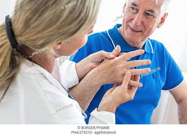 Doctor examining the hand of elderly man