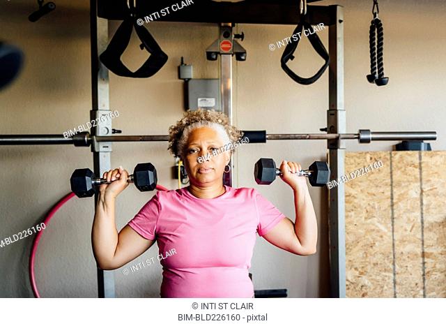 Black woman lifting weights in garage