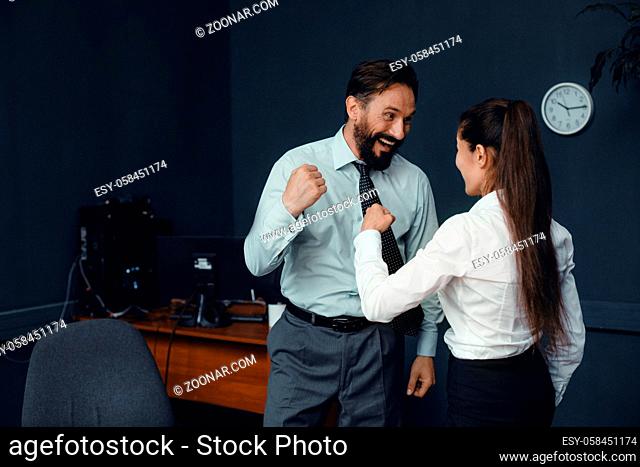 Young business people in office clothes showing fists to each other. Fight of genders concept