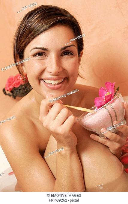 Woman with a bowl with bath salts and petals