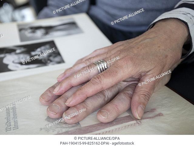 11 April 2019, Hessen, Bruchköbel: While they leaf through an old photo album, Edith Wolf holds the hand of her husband Waldemar