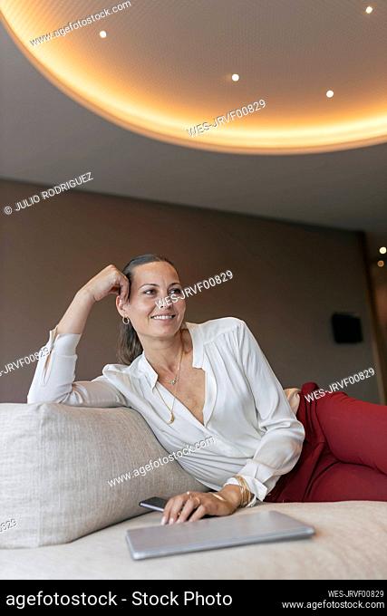 Smiling female entrepreneur sitting on sofa